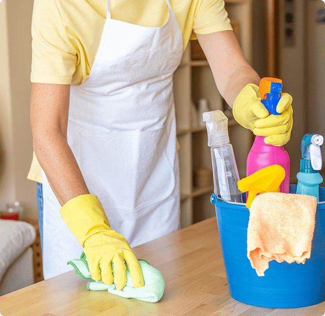 A person in yellow gloves cleaning the counter.